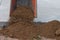 Pile of soil poured from the wheelbarrow in construction site.