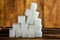 Pile of Sugar Cubes Stacking on Table over Wooden Background.