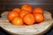 Pile of tangerines in a wooden bowl