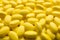 Pile of tasty yellow dragee candies as background, closeup