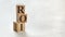 Pile with three wooden cubes - letters ROI meaning Return on Investment on them, space for more text / images at right side