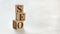 Pile with three wooden cubes - letters SEO meaning Search Engine Optimization on them, space for more text / images at right side