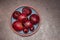 Pile of unpeeled bulbs of beetroot in different sizes on round plate standing on dark table