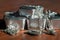 A pile of various silver coins, silver bars and jewelry on a mahogany table.