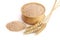 Pile of wheat bran in wooden bowl with ears on white background