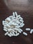 Pile of white pills on table, medicine, pharmaceuticals