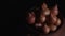 Pile of whole bulbs of raw onion in ceramic bowl on table. Harvest of unpeeled vegetables on black background