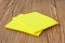 Pile of the yellow micro fiber napkins on wooden background. Household