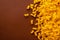 A pile of yellow pasta on a brown surface. AI generative image . A lot of copy space.