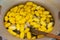 Pile of yellow silkworm cocoons being boiled and getting ready to spun into silk thread at a silk factory.