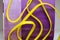 Pile of yellow small rubber bands isolated on a purple back ground