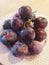 Piled purple plum fruits on a white platter