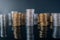 Piles of coins (polish zloty, grosze, PLN) on a black, reflective surface.