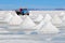 Piles of drying salt and reflection in the water at the Salar de Uyuni salt flats in Bolivia