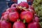 Piles of fresh beautiful shiny dark red pomegranate fruit selling in local city market with blurred background