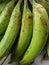 Piles of green bananas are sold in the local Indonesian market. Banana branch at the market. files 3