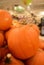 Piles of large pumpkins in grocery store.