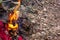 piles of leaves and leftover cloth burned by a small fire on the rocks