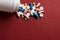 Piles of pills and capsule on red background. Copy space for text