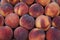 Piles of seasonal fresh sweet juicy gradient color peach background in local city fruit market