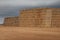 Piles of stacked rectangular straw bales in a farmland.