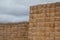 Piles of stacked rectangular straw bales in a farmland.