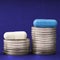 Piles of steel coins and pills on a dark blue background