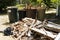 Piles of wood on ground and in garbage pails from removing a deck