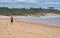 Pilgrim with backpack going on beach on Camino de Santiago