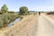 Pilgrim walking a country road in los Berrocales natural Park at Sierra Norte, Seville