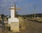 Pilgrims by bike in the Camino de Santiago, passing by a cross mark with information about the route. Spain.