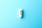 Pill in capsule with happy face on blue background