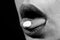 Pill and the mouth, isolated on black background. Close up woman with pills supplement. Vitamins, natural beauty