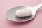 Pill and spoon detail. Pink background. Medicament treatment. He