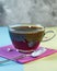 Pill of sugar substitute - sweetener falling into a cup of coffee on a purple podium