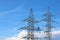 A pillar with high voltage power lines against a blue sky. Clean energy