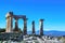 Pillars from Temple of Apollo in ancient ruins of Corinth Greece with snowtopped mountains in the background