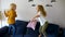 Pillow fight. Mischievous preschooler children jumping on a sofa and hitting each other with pillows. Boy and girl play together.