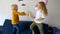 Pillow fight. Mischievous preschooler children jumping on a sofa and hitting each other with pillows. Boy and girl play together.