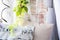 Pillow with musical notes on the windowsill with flowers. Brick wall background with artificial flowers