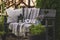 pillows and blanket on cozy rustic wooden bench in summer garden.