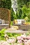 Pillows on rattan sofa on wooden veranda with pouf in the garden