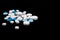 Pills and capsules on a black background. Medicines and dietary supplements