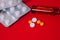 Pills and drugs blisters and ampoule on red background. Healthcare wallpaper. Medical package