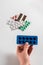 Pills in a female hand on a background of colorful pills and capsules in blister packs on a white background. Coronavirus.