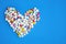 Pills heart on a blue background top view.