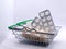 Pills and other medicines in a grocery basket on a light background