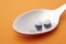 Pills and spoon detail. Orange background. Medicament treatment.