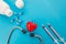 Pills, stethoscope, syringes and a red heart on an isolated blue background. Medical concept