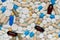 Pills texture background, different assorted drugs capsules on blue background